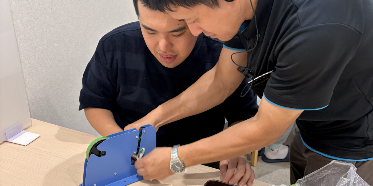 生活介護で職員のサポートを受けながら軽作業に取り組む様子