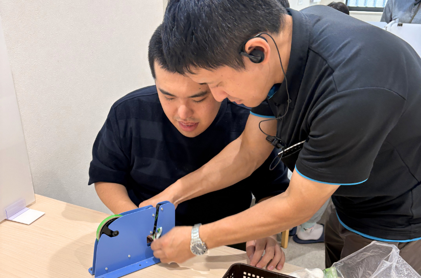 生活介護で職員のサポートを受けながら軽作業に取り組む様子